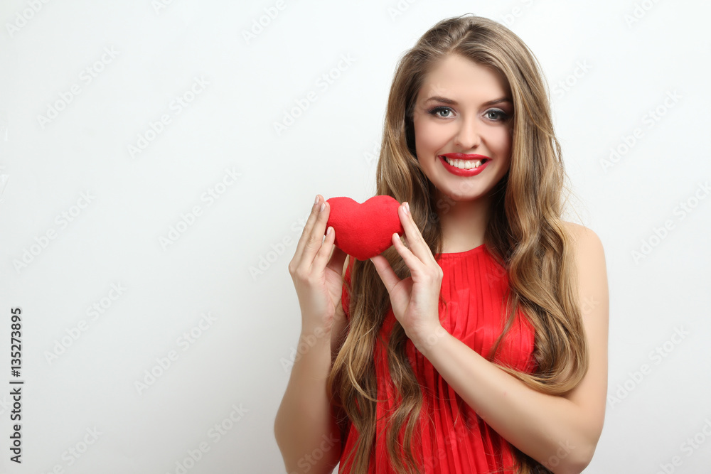 Happy girl holding a red decorative heart. Happy girl holding a red decorative heart.