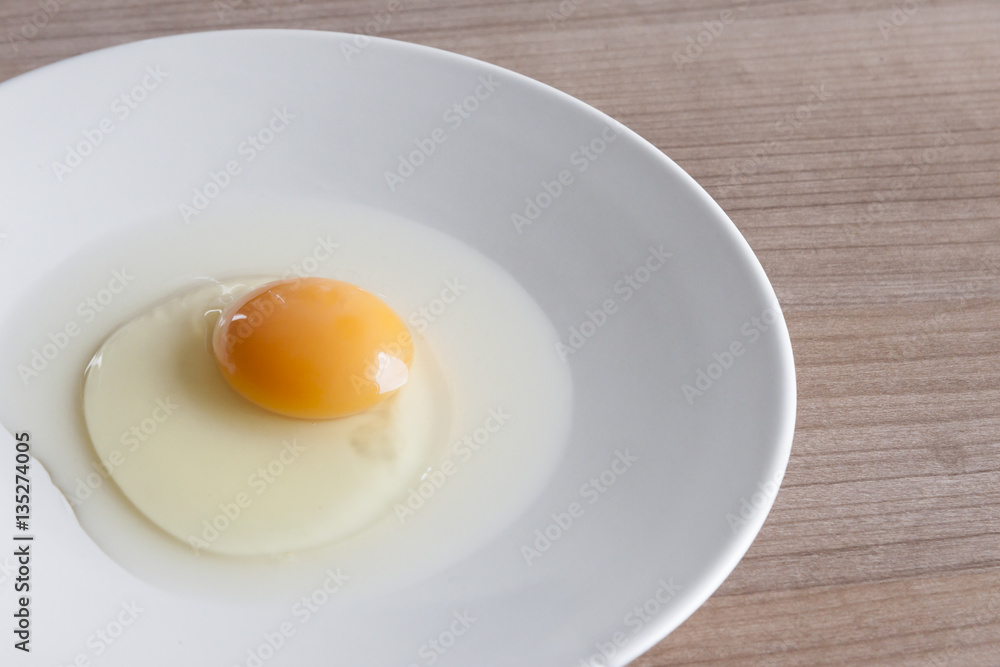Eggs cooking for breakfast, a protein form yolk and albumen on a white background, or on a plain wooden table. Eggs cooking for breakfast, a protein form yolk and albumen on a white background, or on a plain wooden table.