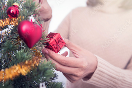 Woman hands decorating Christmas tree