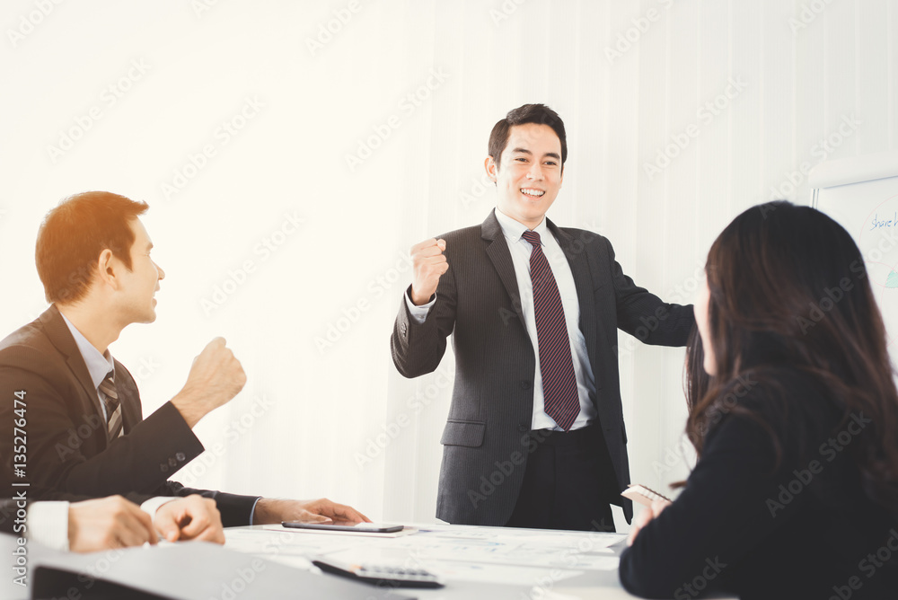 Powerful businessman clenching his fist empowering his colleague in the meeting