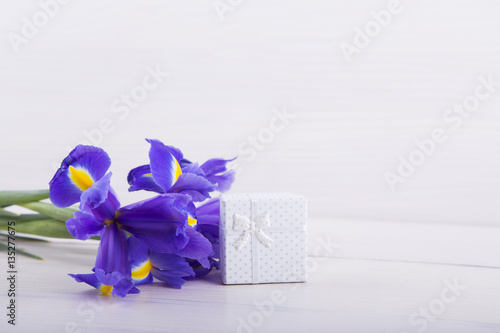 Fototapeta Naklejka Na Ścianę i Meble -  Bouquet of irises with gift box on white wooden background