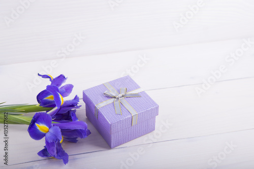 Fototapeta Naklejka Na Ścianę i Meble -  Bouquet of irises with gift box on white wooden background