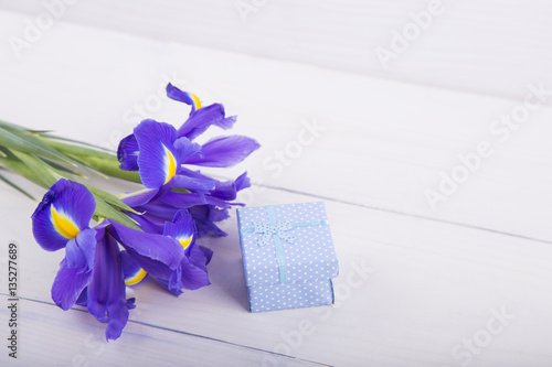 Fototapeta Naklejka Na Ścianę i Meble -  Bouquet of irises with gift box on white wooden background