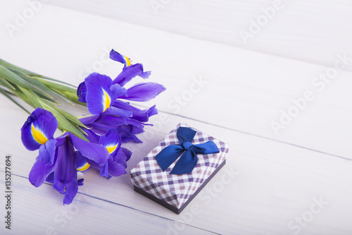 Fototapeta Naklejka Na Ścianę i Meble -  Bouquet of irises with gift box on white wooden background