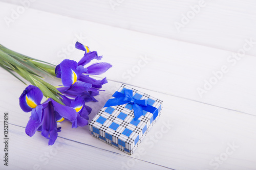 Fototapeta Naklejka Na Ścianę i Meble -  Bouquet of irises with gift box on white wooden background
