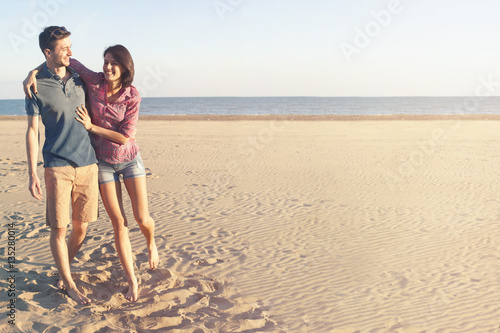 happy couple walking along the beach
