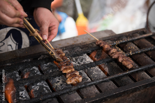 In the picture we can see a man frying a food on a grill. This is a famous street food preparation.