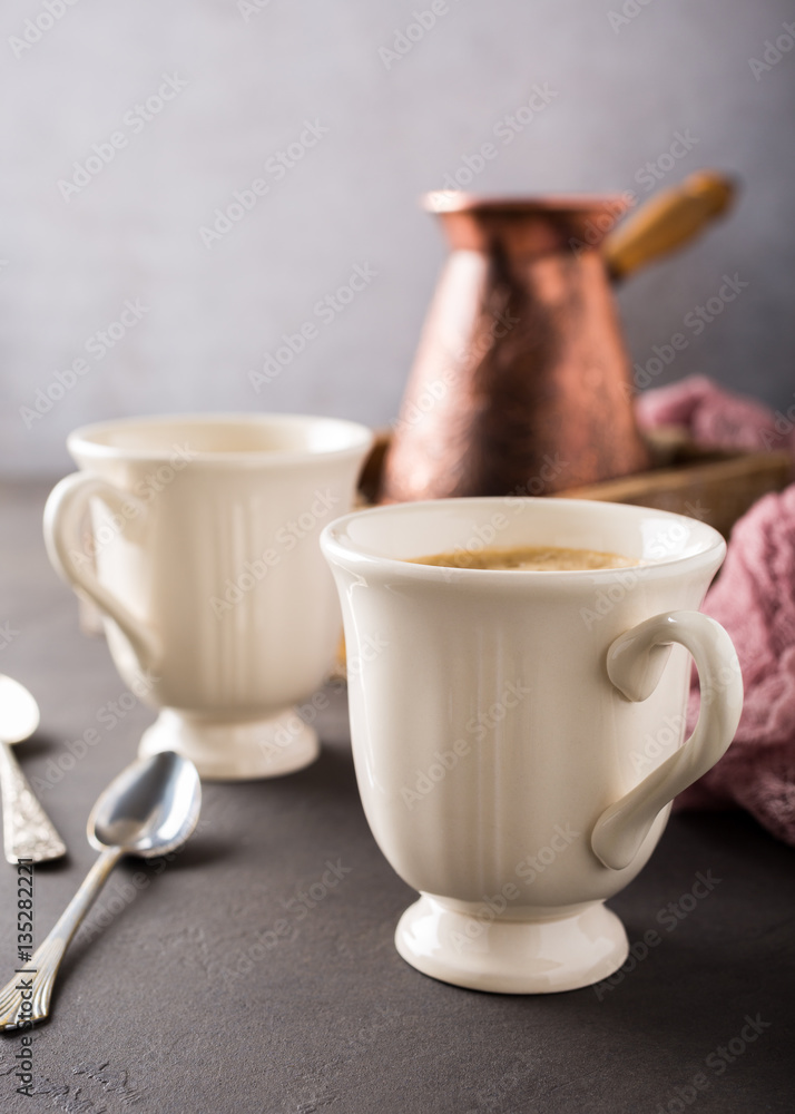 Two retro cups of coffee and old coffee pot on dark brown background with copy space. Two retro cups of coffee and old coffee pot on dark brown background with copy space.