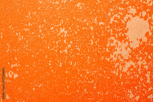 Bright orange shabby texture with peeling paint close-up shot