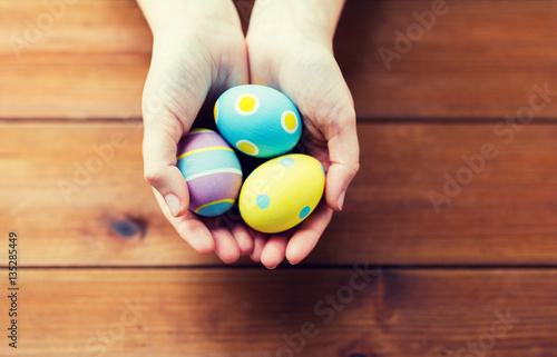 close up of woman hands with colored easter eggs