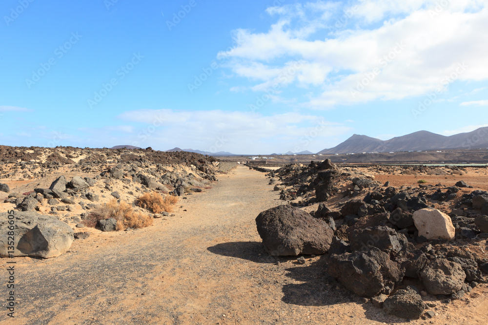 A road going through lava landscape in the Canary island of Lanzarote