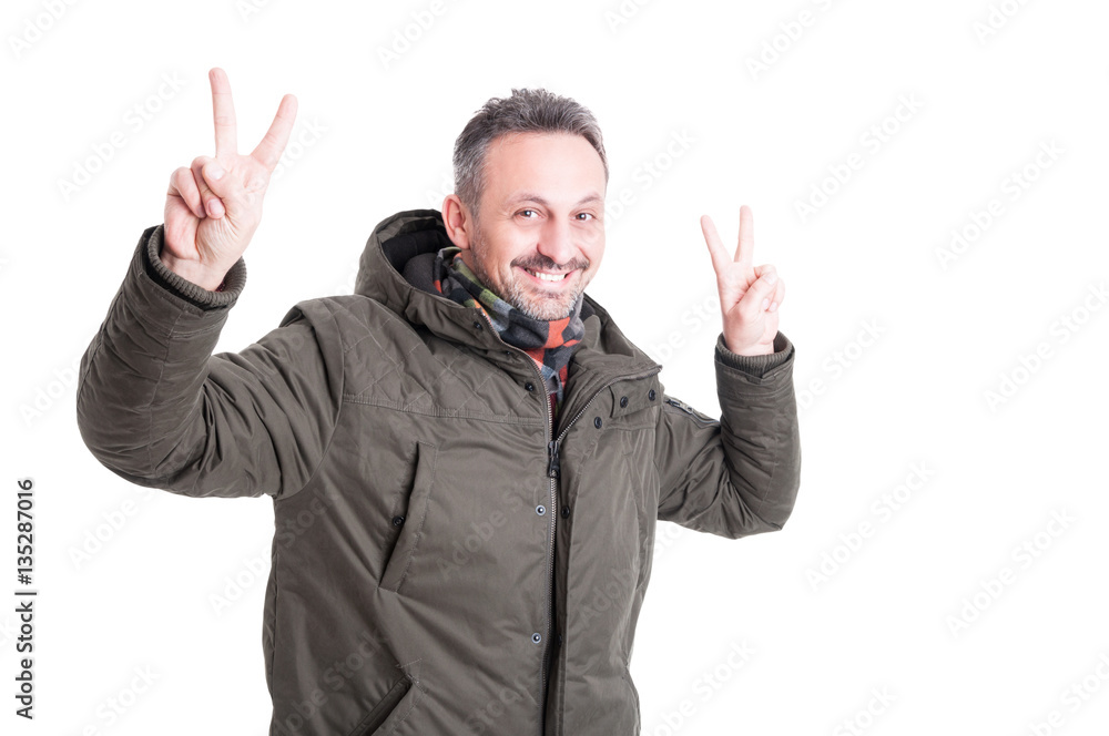 Male posing wearing winter jacket showing peace gesture
