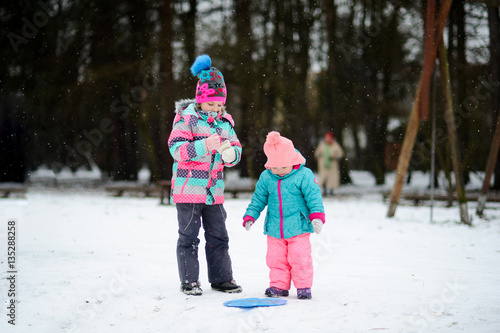 Two little girls on walk in winter day.