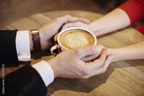 Close up of human hands holding cup of coffee