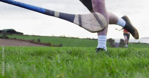 Hurling player strikes ball while being tackled