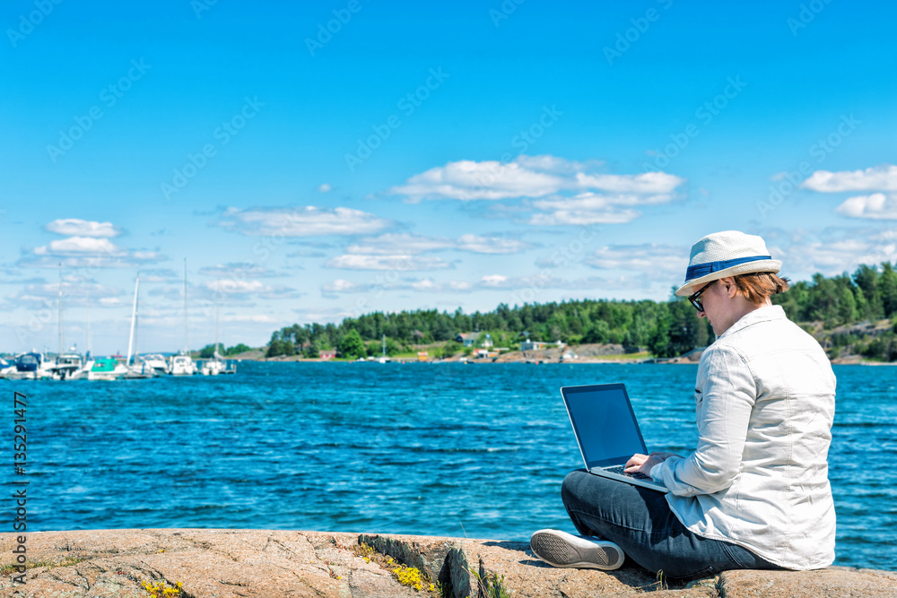 Freelancer woman working with laptop on the beach Freelancer woman working with laptop on the beach