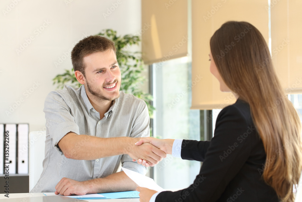 Employee and boss handshaking after a job interview Employee and boss handshaking after a job interview
