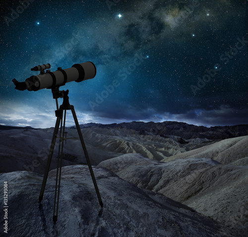 telescope tripod pointing the milky way in a desert landscape