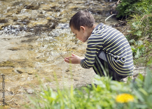 Child by playing in river water