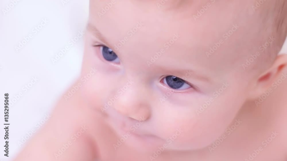 naked baby is five months old looking at the camera with his big blue eyes naked baby is five months old looking at the camera with his big blue eyes