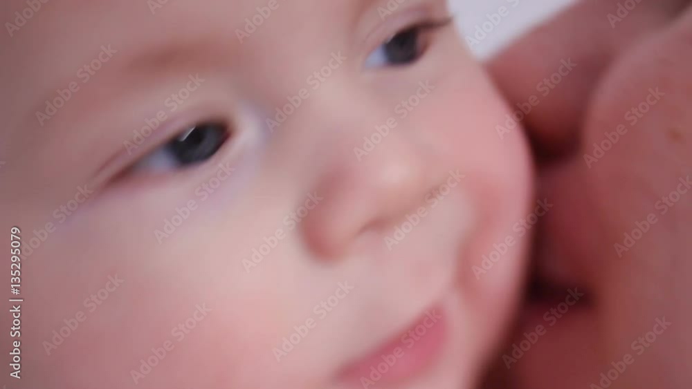 happy mother kissing her son's baby in studio on white background happy mother kissing her son's baby in studio on white background