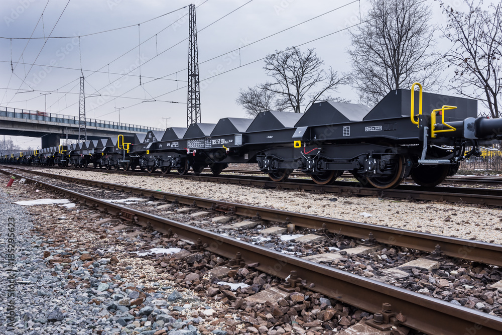 Burgas, Bulgaria - January 24, 2017 - Freight cargo train - black cars wagons - New 6-axled flat wagon - Type: Sahmmn - Model WW 604 A - Transvagon AD Burgas, Bulgaria - January 24, 2017 - Freight cargo train - black cars wagons - New 6-axled flat wagon - Type: Sahmmn - Model WW 604 A - Transvagon AD
