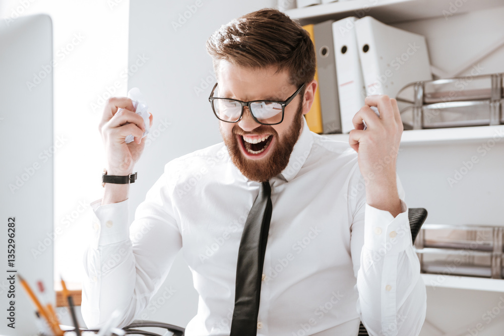 Angry young businessman holding documents. Angry young businessman holding documents.