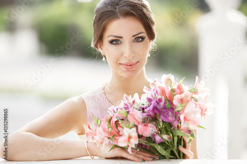 beautiful spring woman with colorful flowers bouquet outdoors