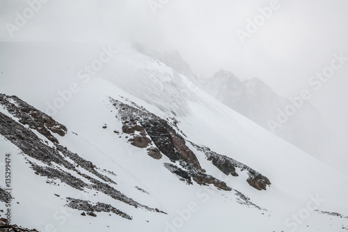 Rocks and snow in clouds. Mountain landcape
