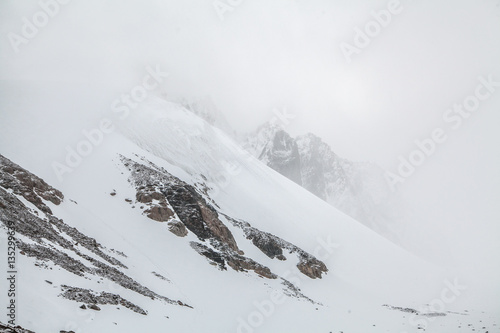 Rocks and snow in clouds. Mountain landcape