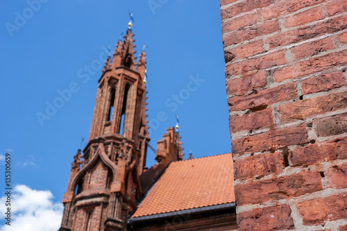 Red brick wall. Church tower on sky backdrop. Visit the God's temple.