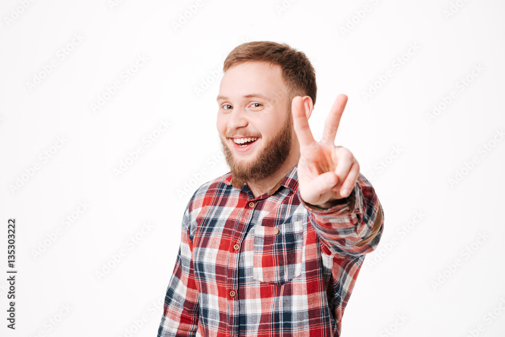 Smiling Bearded man in shirt showing peace sign Smiling Bearded man in shirt showing peace sign