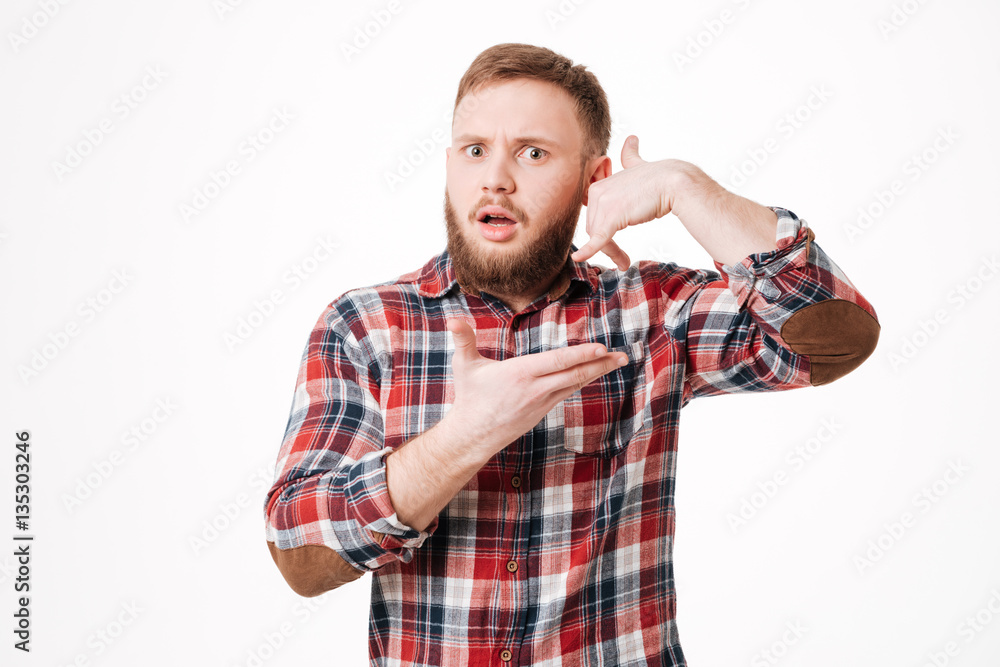 Surprised Bearded man in shirt showing phone sign Surprised Bearded man in shirt showing phone sign