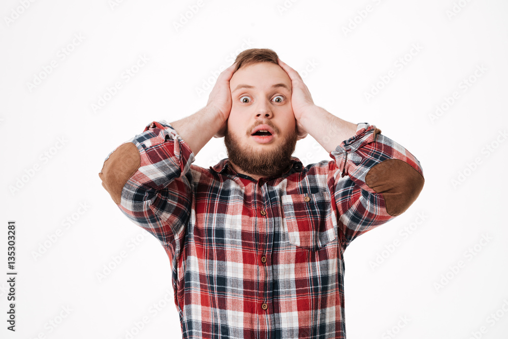 Surprised Bearded man in shirt holding his head Surprised Bearded man in shirt holding his head
