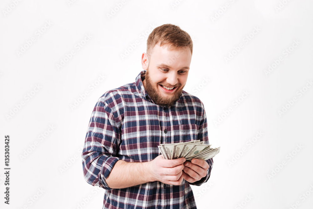 Happy Bearded man in shirt considers money Happy Bearded man in shirt considers money