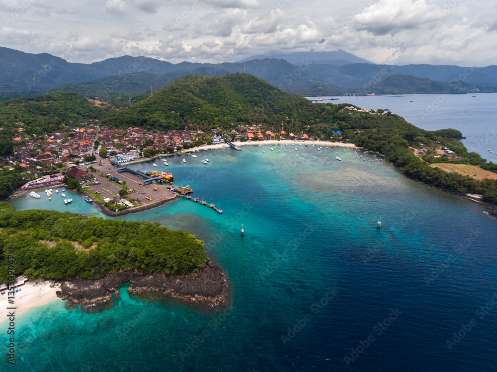 Aerial view of the tropical bay with marine port and town named Padang Bai, island of Bali, Indonesia