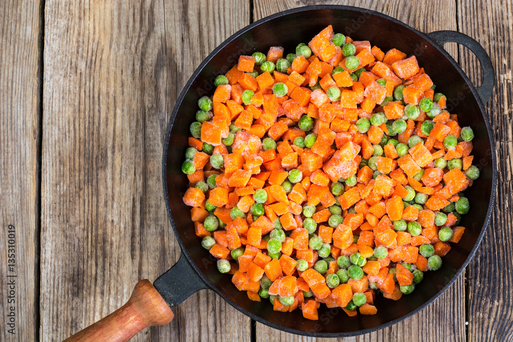 Frozen peas and carrots for cooking on a pan