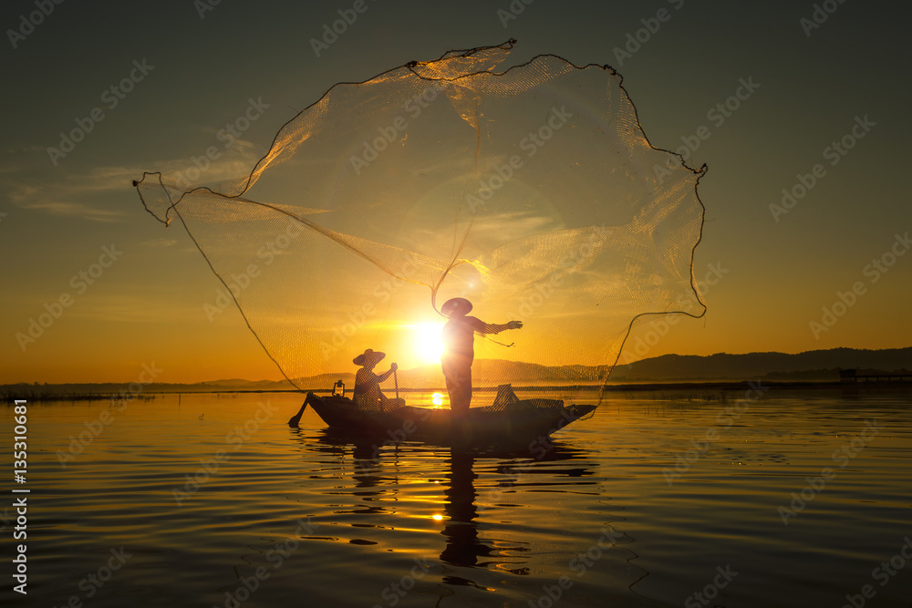Naklejka premium Fisherman of asian people at Lake in action when fishing during
