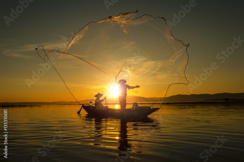 Fisherman of asian people at Lake in action when fishing during