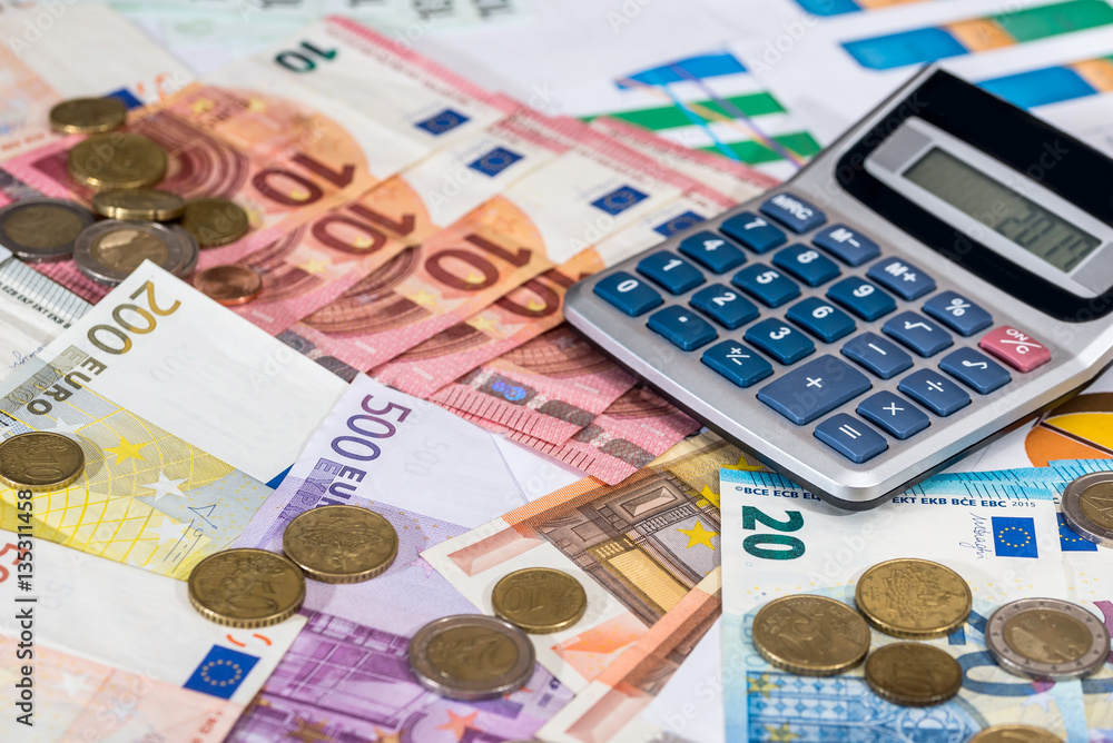 calculator and euro coin lying on euro bills. calculator and euro coin lying on euro bills.