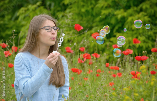 Young girl with soap bubbles in forest