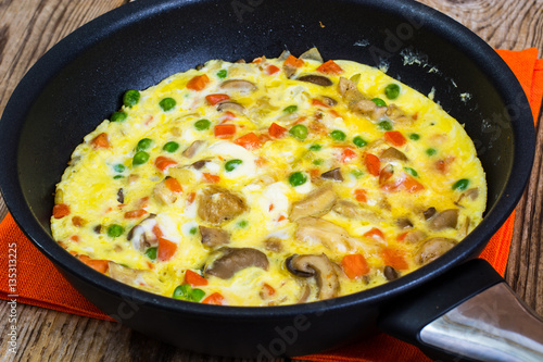 Omelet with vegetables in a pan