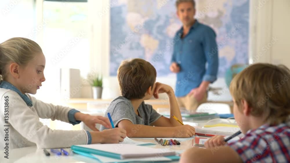 Teacher standing in classroom, kids attending geography lesson Teacher standing in classroom, kids attending geography lesson