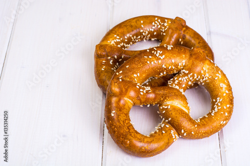 Obraz na plátně Bavarian pretzels with sesame seeds on white boards