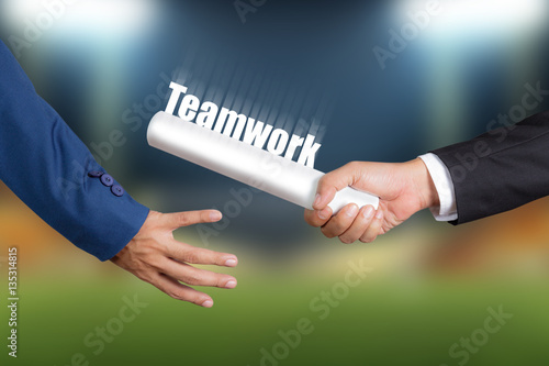 Fotografie Cropped hand of businessman passing relay baton to colleague