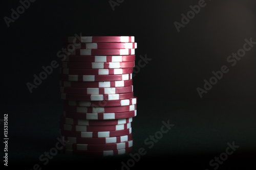 Stack of red poker chips on a dark background