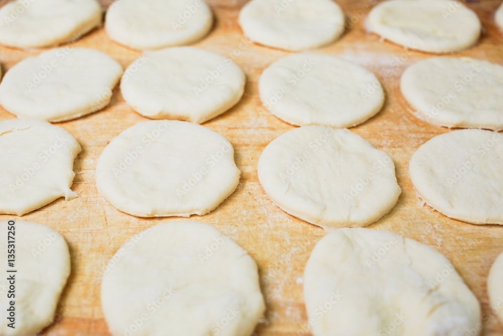 Raw sweet yeast dough on a wooden table. Preparation for baking. The concept of chefs and baking.