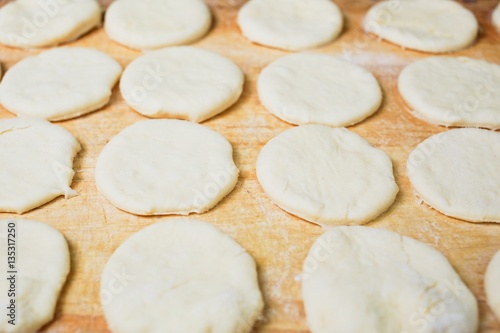 Raw sweet yeast dough on a wooden table. Preparation for baking. The concept of chefs and baking.