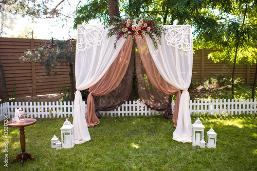 Beautiful wedding ceremony outdoors. Decorated chairs stand on t