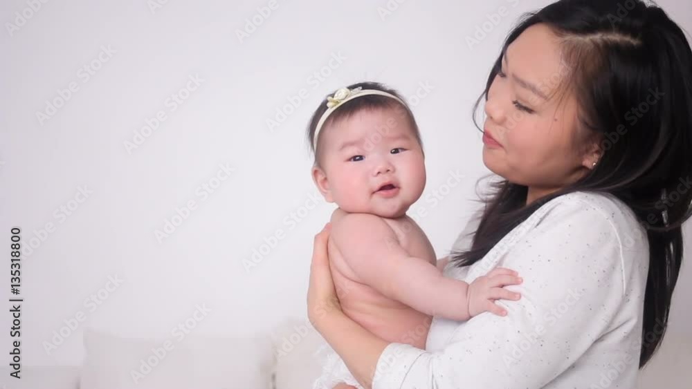 young mother kissing little daughter asian in studio young mother kissing little daughter asian in studio